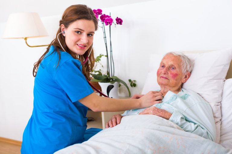 elder woman in a hospital bed with nurse