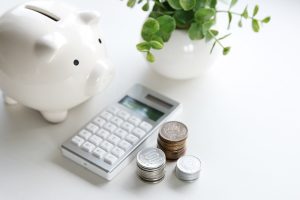 white piggy bank with calculator and coins
