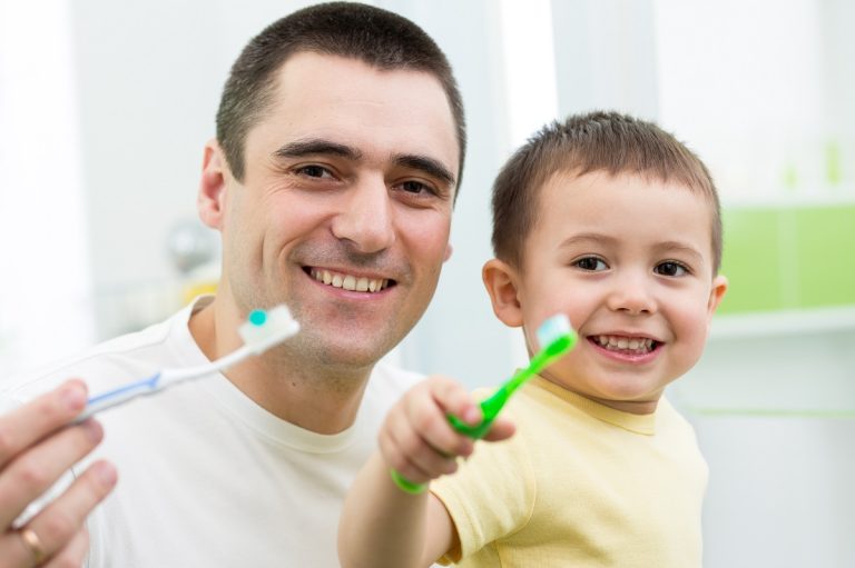 father and son holding a toothbrush