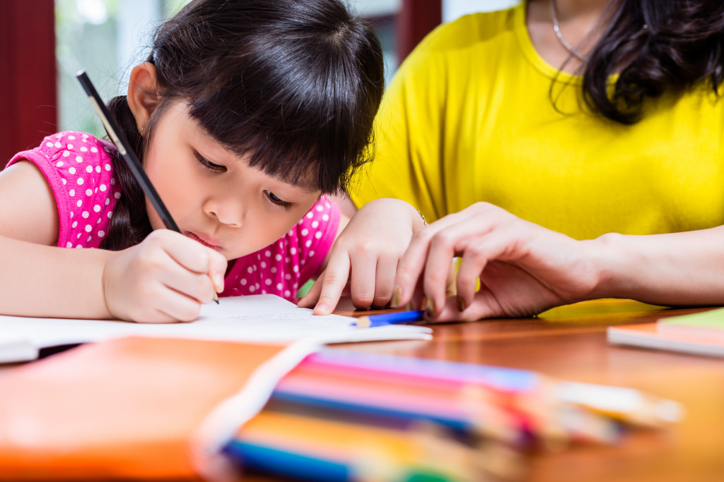 mother teaching her daughter to write